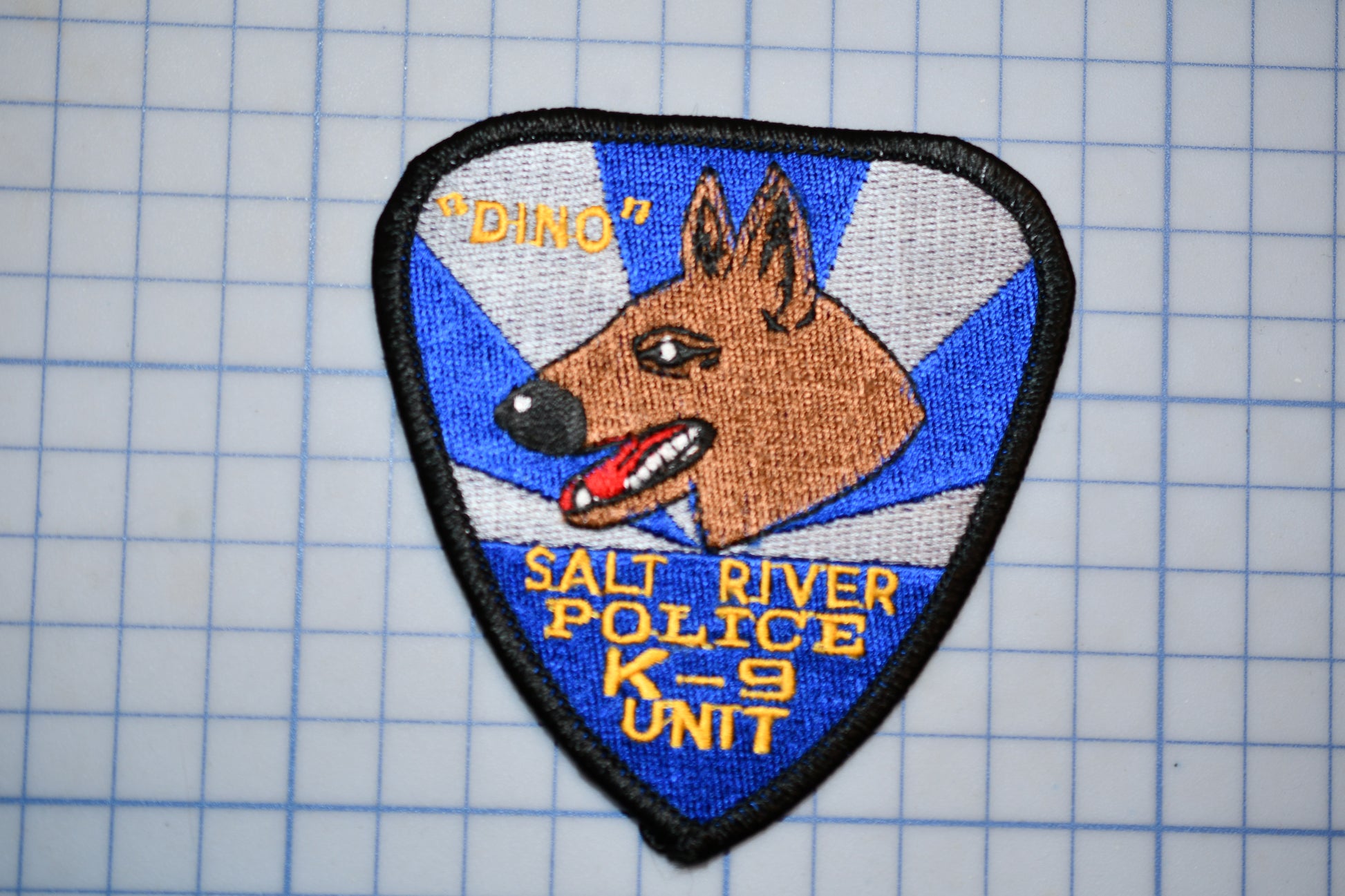 A police dog patch with the text "DINO" and "SALI RIVER POLICE K-9 UNIT" on it.