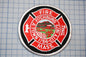 a circular patch with a red border and white text, which appears to be a patch related to the fire department of a town.