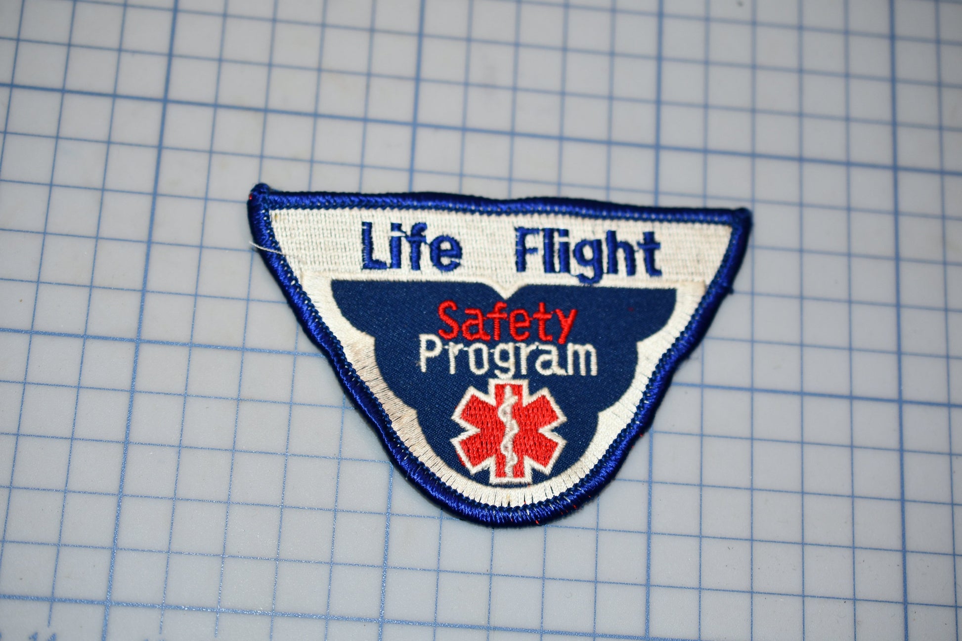 a patch with the text "Life Flight Safety Program" and a medical symbol, indicating it is a safety program related to aviation.