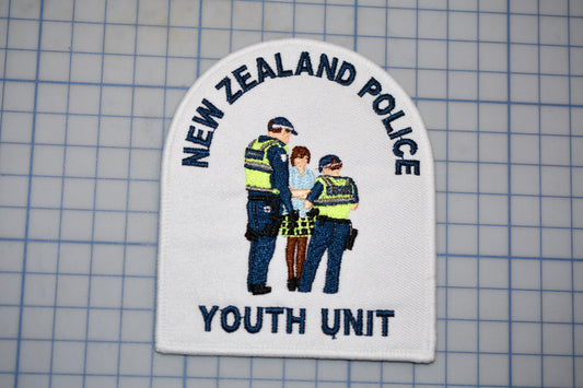 a patch with the text "NEW ZEALAND POLICE Youth Unit" and an illustration of three police officers.