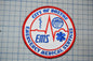 a circular patch with the text "CITY OF BOSTON EMT" and "EMERGENCY MEDICAL SERVICES" written on it.