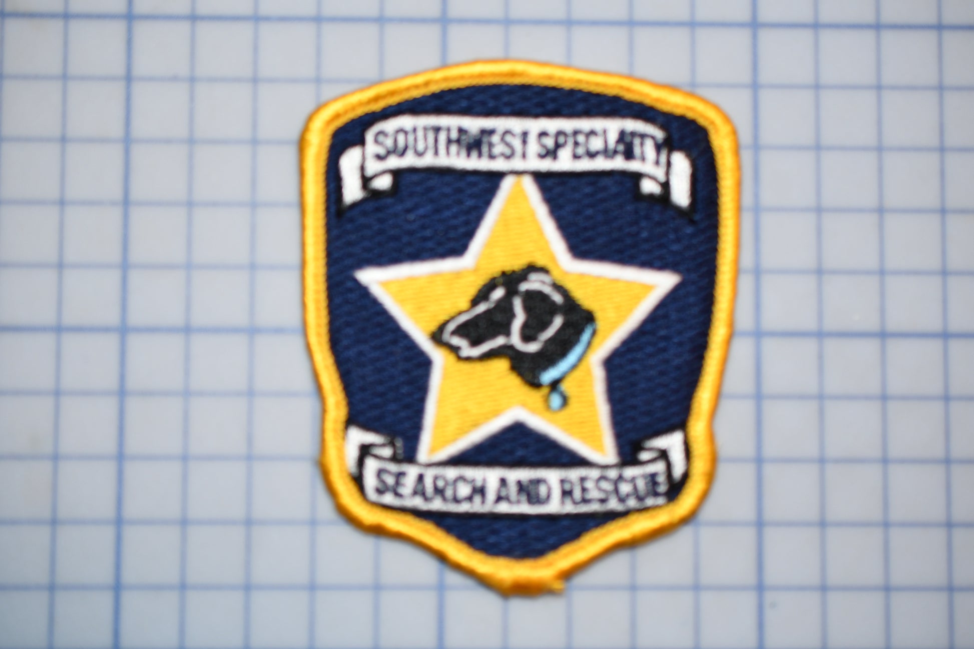 a badge with a dog on it, which is part of the Southwest Specialty Search and Rescue team.