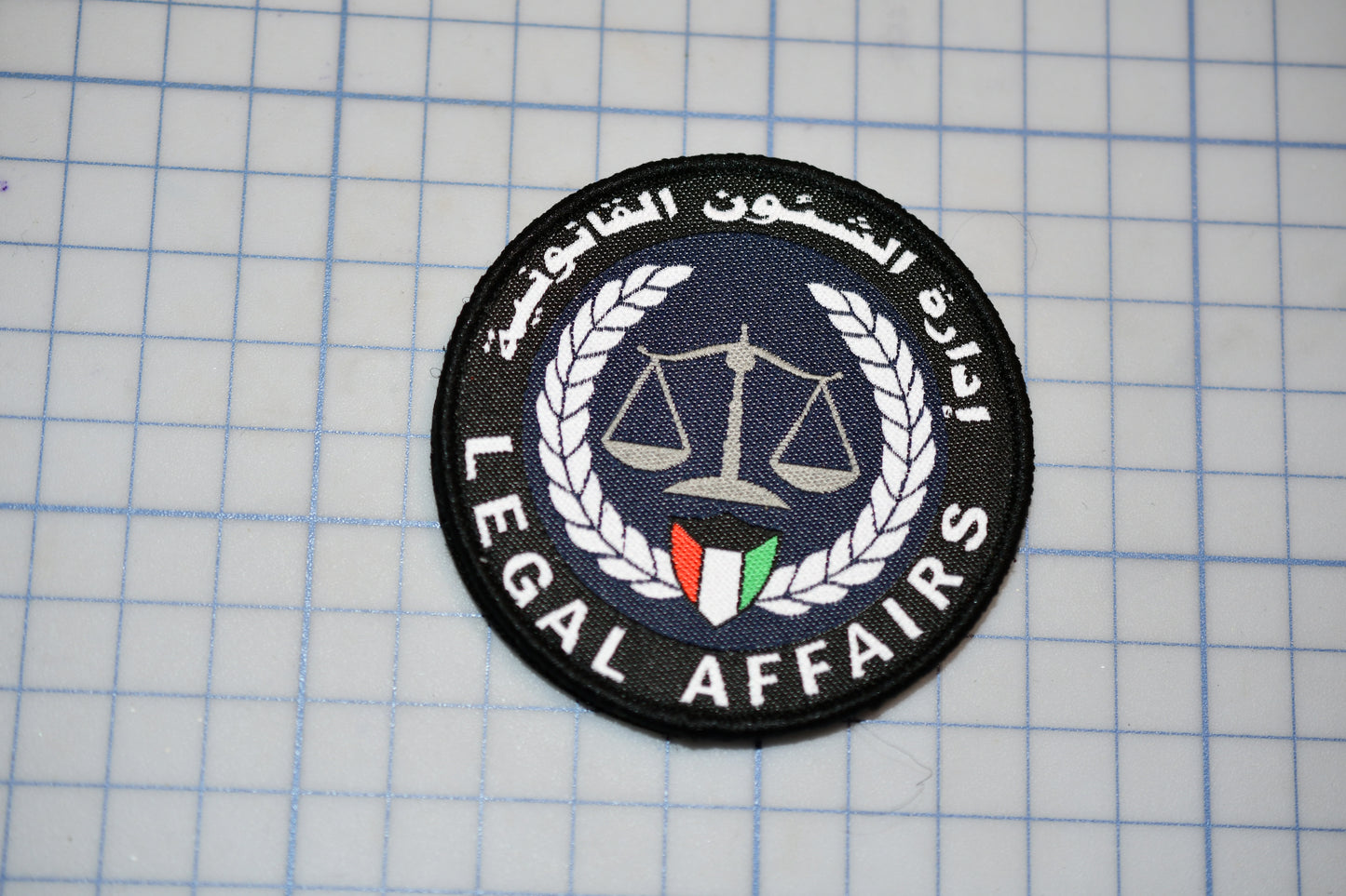 a circular patch with a logo, surrounded by a wreath and the text "Legal Affairs".