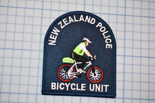 A New Zealand Police Bicycle Unit patch is shown, featuring a police officer riding a bicycle.