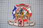 a patch with a fire department emblem, including a fire engine, horses, and a banner with the number 3.