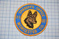 A patch with a dog's head and the text "Sheriff's Office" around it, placed on a grid background.