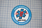 a blue and white patch with a medical symbol and text, placed on a grid background.