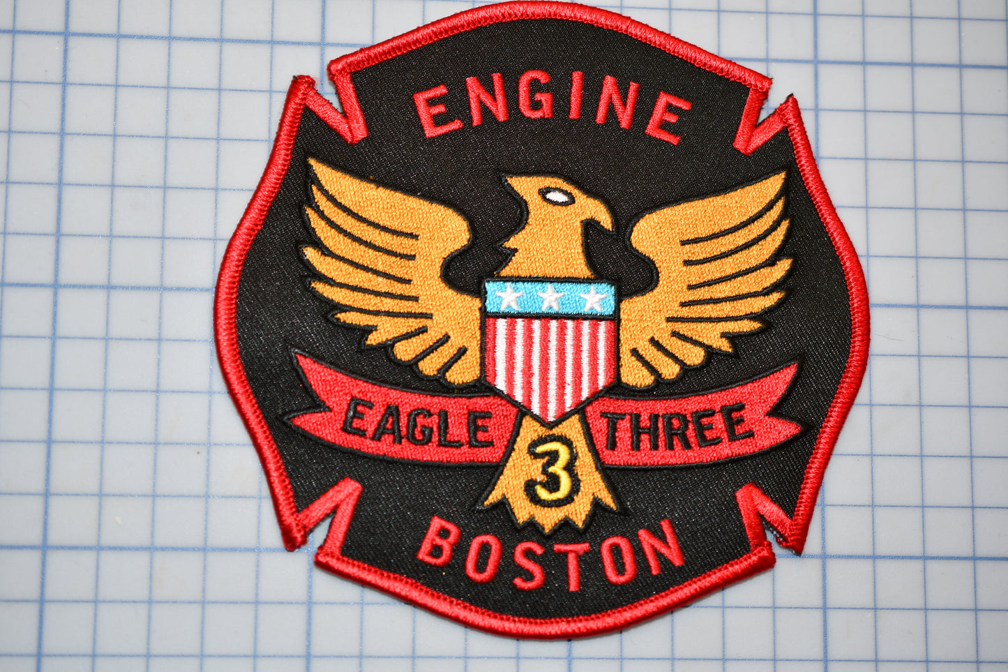 a patch with an eagle three boston on it