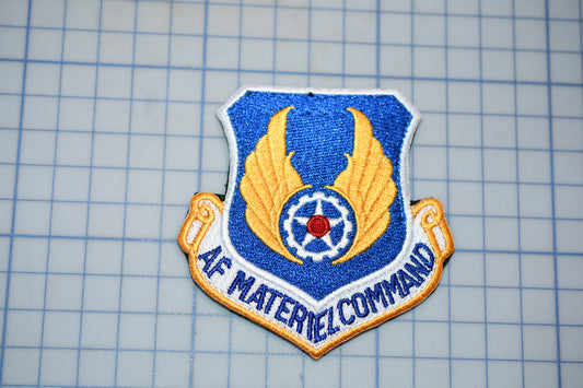 a blue and gold military insignia with wings and a star, which appears to be a patch or emblem.