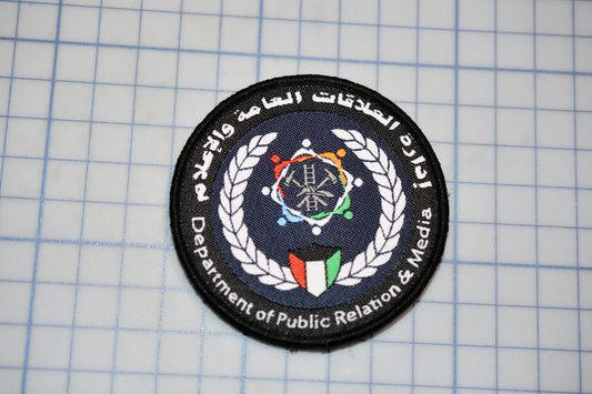 a circular patch with a logo and text, placed on a grid background.