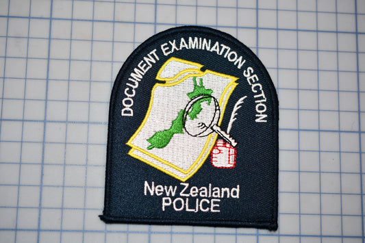 a black and white patch with text and an emblem, likely representing the New Zealand Police.