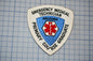 a patch with the text "EMERGENCY MEDICAL TECHNICIAN ARIZONA PRIMARY GRADUATE" and a red cross symbol, indicating that it is a patch for an emergency medical technician.