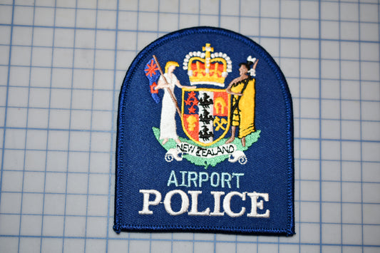 a blue patch with a coat of arms and text, representing the Airport Police of New Zealand.
