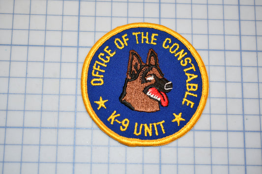 a circular patch with a dog's head and the text "OFFICE OF THE CONSTABLE K-9 UNIT" on it.