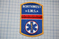a patch with the text "NORTHWEST EMS" and a medical symbol, likely representing the Northwest Emergency Medical Services (EMS) of the United States.