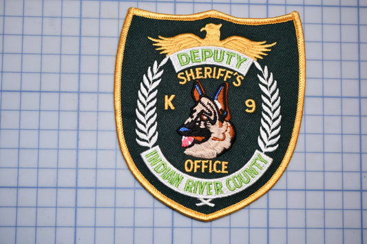 a badge with the text "DEPUTY SHERIFF'S K-9 INDIAN RIVER COUNTY" and an embroidered image of a German Shepherd dog.