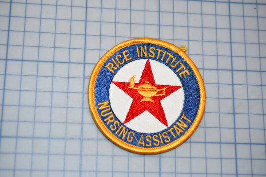 a patch with the text "RICE INSTITUTE NURSING ASSISTANT" and a red star, all set against a blue and white grid background.