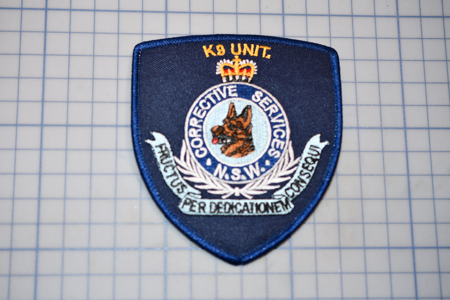 a blue police badge sitting on top of a piece of paper