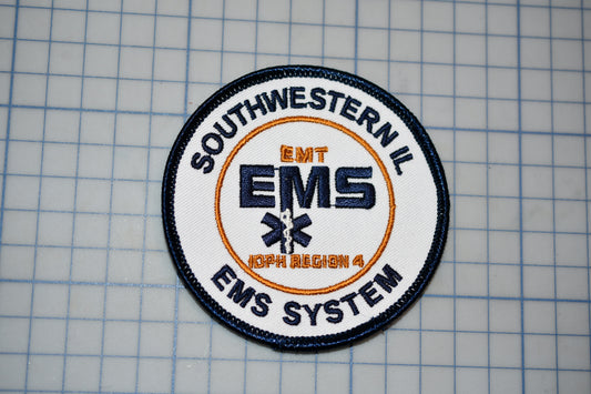 a patch with the text "EMT EMS" and "EMS SYSTEM" printed on it, along with a symbol of an ambulance and a cross.