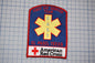 a patch with the text "Fast Aid Service Team" and "El Paso, Texas" written on it, along with a red cross symbol. The patch also displays the text "American Red Cross" at the bottom.