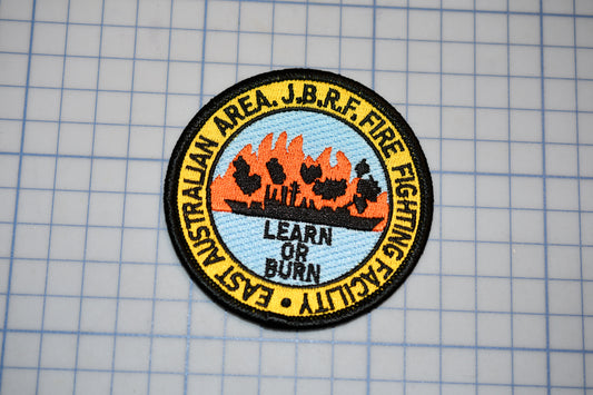 a circular patch with a graphic design and text, placed on a grid background.