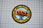 a circular patch with a graphic design and text, placed on a grid background.