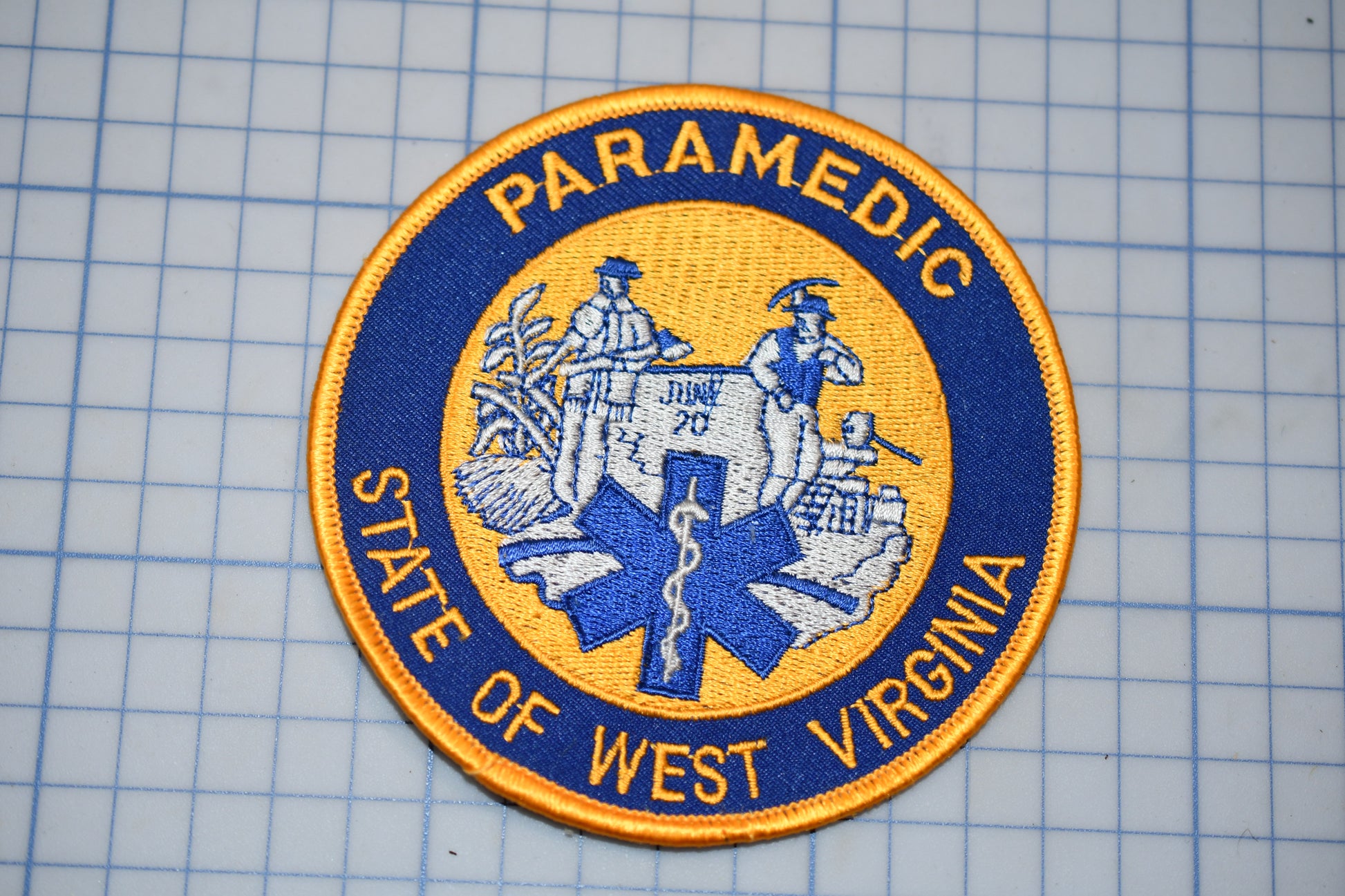 a patch with the text "PARAMEDIC STATE OF WEST VIRGINIA" and a graphic of a medical symbol, likely representing the West Virginia Paramedic State.