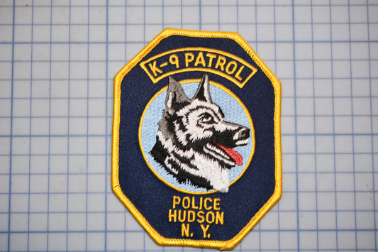 A police K-9 patrol badge with the text "K-9 PATROL" and "POLICE HUDSON N.Y."