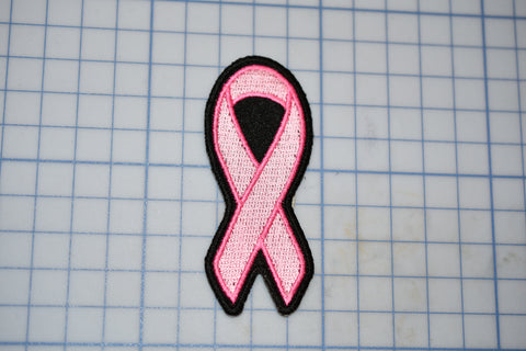 a pink ribbon on a piece of paper