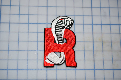 a red and white patch with a skeleton on it