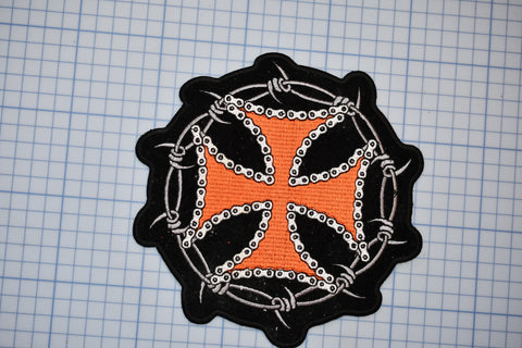 an orange and black patch with a cross on it