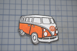 an orange and white vw bus on a cutting board