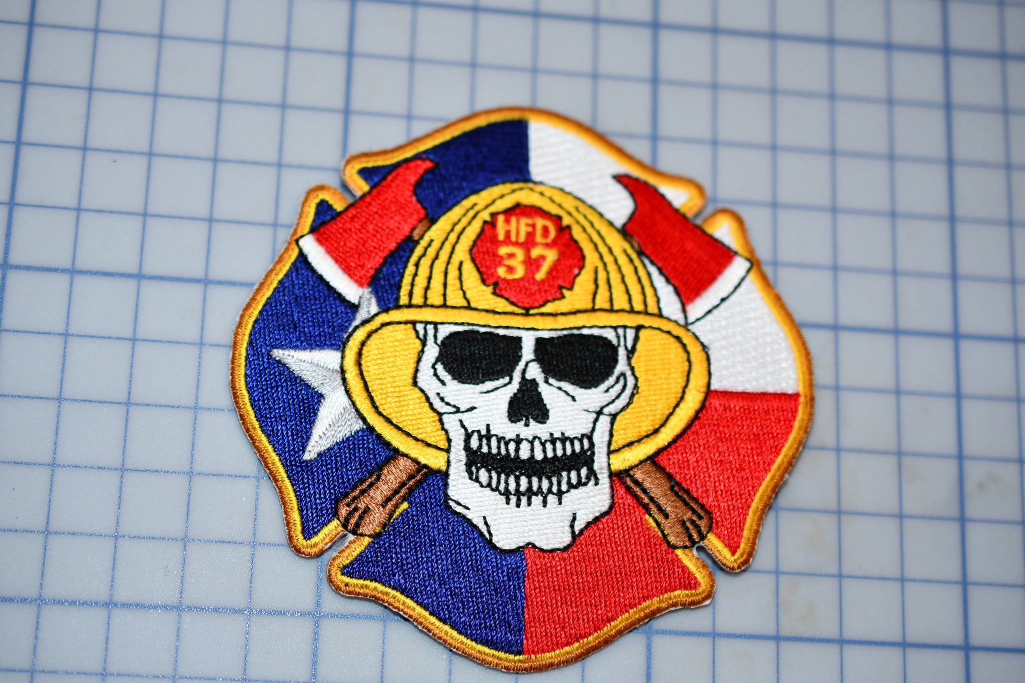 a patch with a skull wearing a fireman's helmet