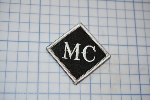 a black and white patch with the letters mc on it