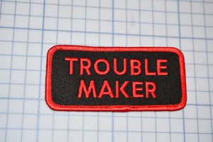 a patch that says trouble maker on it